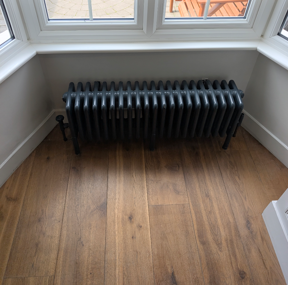 Dark traditional column radiator under window
