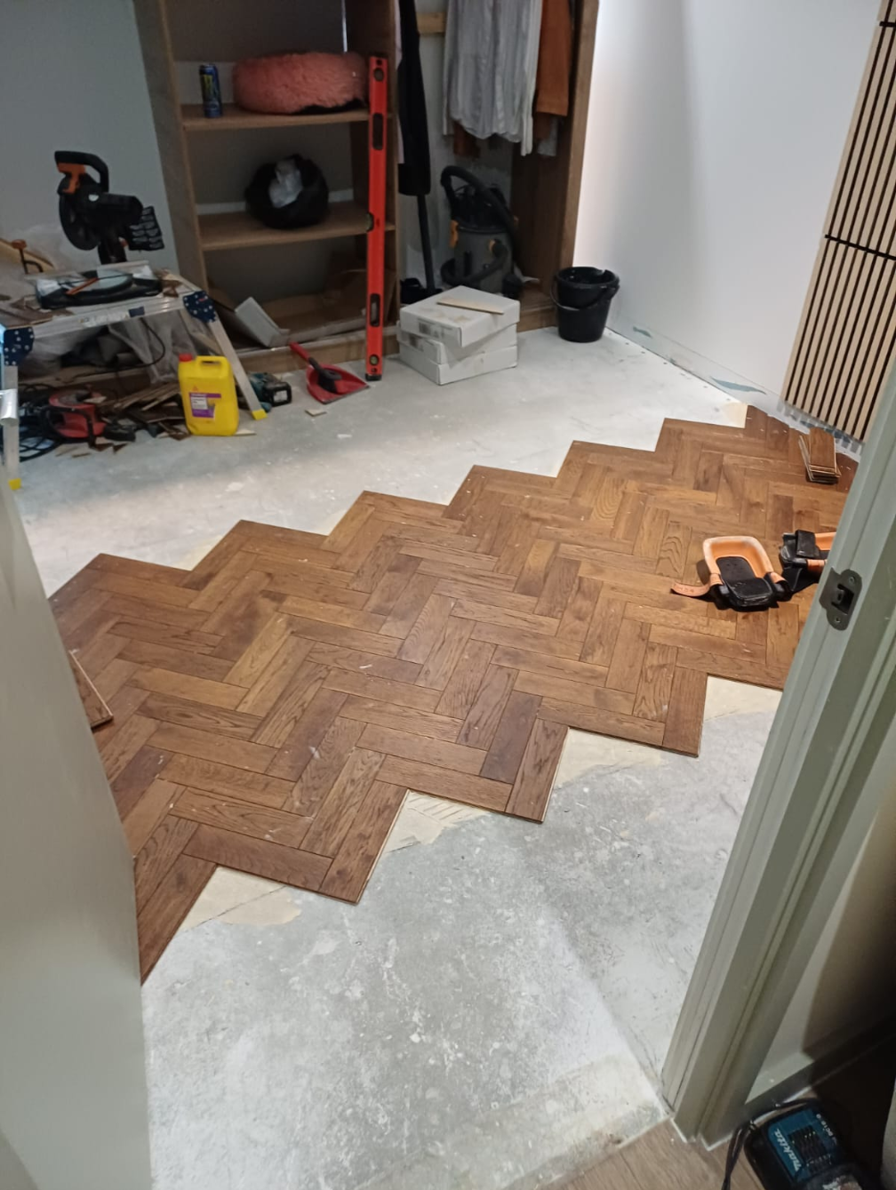Wooden herringbone flooring installation in progress room