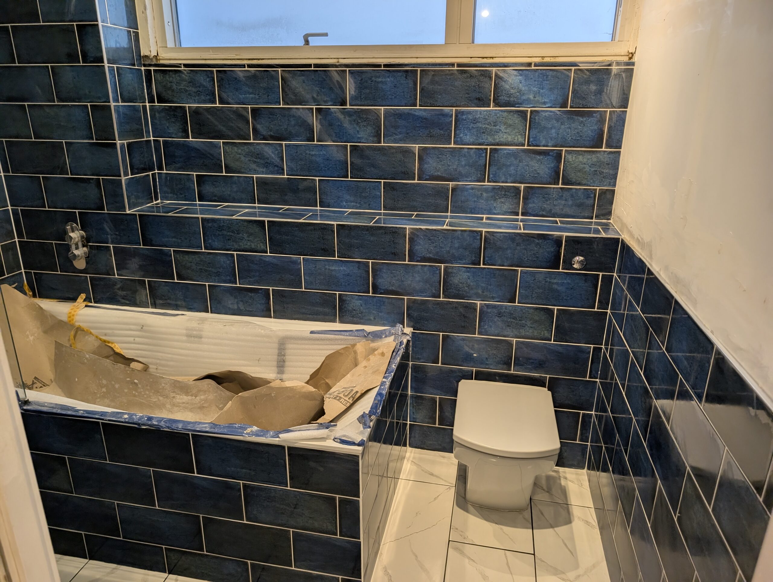 Bathroom under renovation with blue tiles